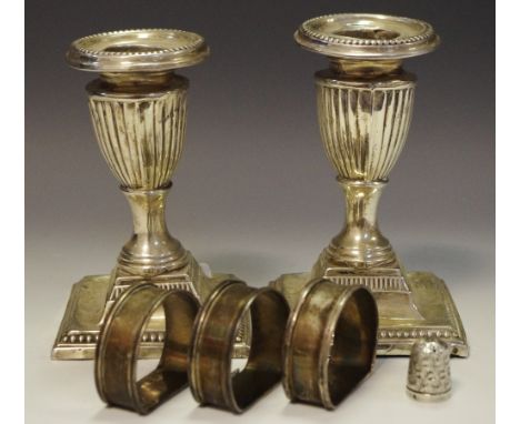 A silver thimble; a silver boudoir candlestick; silver napkin rings