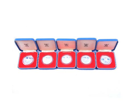 Eight UK silver Crown coins, and a silver piedfort 10p, all boxed.