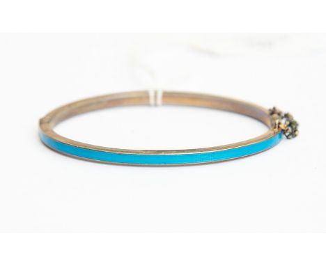 An early 20th Century silver and enamel bangle, comprising peacock blue guilloche enamel, hinged, width approx 3mm, internal 
