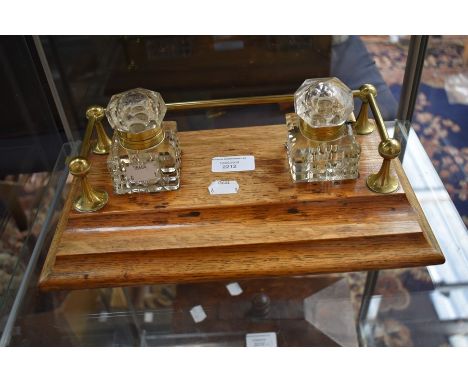 An early 20th Century light oak ink stand with pair of cut glass ink wells