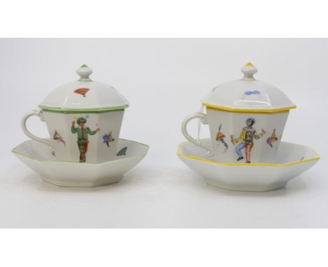 A pair of late 20th Century Dresden covered hot chocolate cups and saucers, both depicting masquerade figures and masks