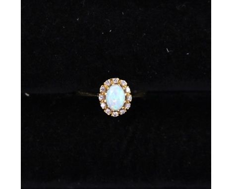 An opal and diamond cluster ring, the oval opal measuring approx 4mm x 6mm, with a diamond set surround, 18ct gold, size O1/2