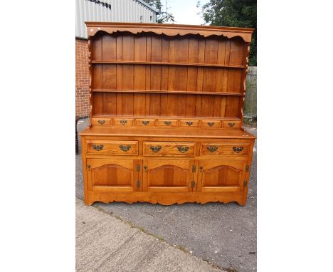 &nbsp;A late 20th Century light oak dresser and plate rack, having three drawers over three cupboards.