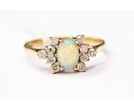 An opal and diamond ring, claw set diamonds set either side of an oval opal, unmarked yellow metal, size L, total gross weigh
