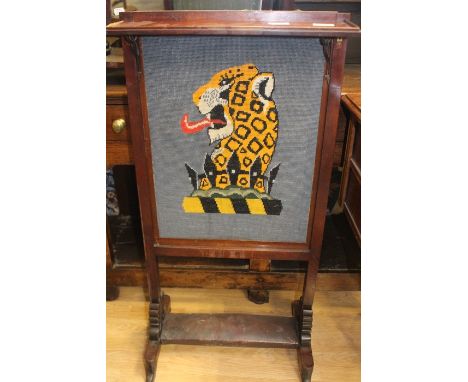 A wooden fire screen with wool work panel depicting a leopard.