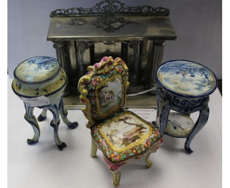 Four dolls house pieces including metal fireplace, two ceramic blue and white tripod tables and ceramic chair A.F
