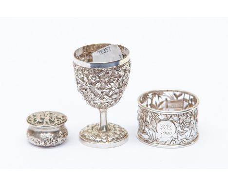 A collection of white metal items to include an Indian silver egg cup, a continental silver pill box and a Chinese silver nap