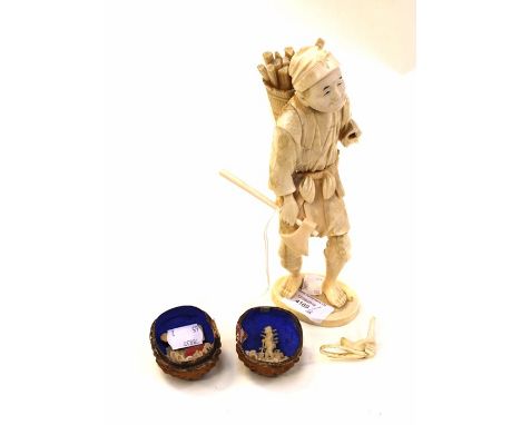 Ivory carved figure of an oriental man carrying a basket of sticks and an axe together with a walnut shell with carved bone i