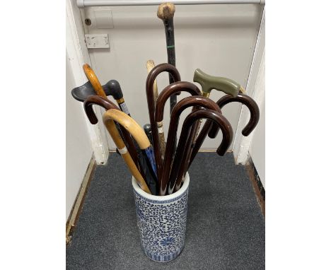 A Blue and White ceramic umbrella and stick stand(there is a hole/damage  on the side of the ceramic stand) and includes all 