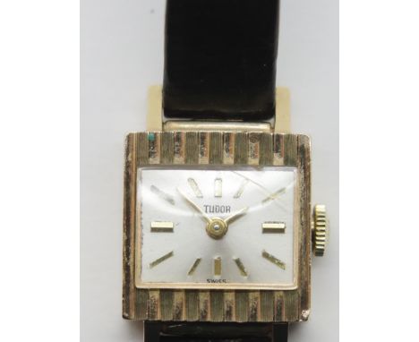 Ladies Rolex Tudor 1960s 18ct gold cased wristwatch with square silver dial on a black leather strap with Rolex gold plated b