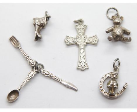Four silver charms and a hallmarked silver cross pendant. P&amp;P Group 1 (£14+VAT for the first lot and £1+VAT for subsequen