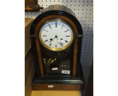 A walnut and ebonised mantel clock with Roman numerals to the enamelled dial