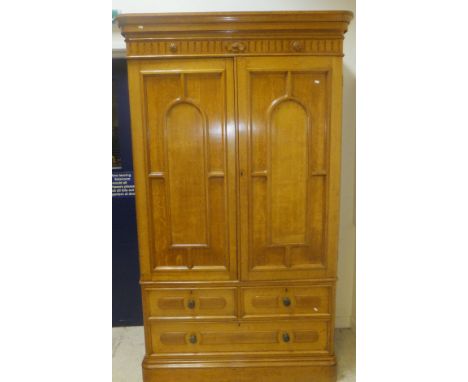A Victorian light oak linen press with moulded cornice above two doors enclosing four linen press shelves on a base of two sh