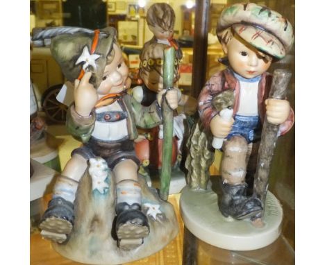 A collection of four Goebel Hummel figures to include "Boy sitting upon mountain top in Tyrolean outfit", "Boy with sheath of