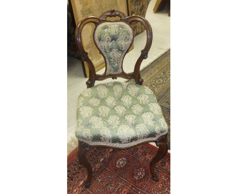 Two Victorian walnut salon chairs with button back upholstered seat and back in green ground foliate patterned upholstery and