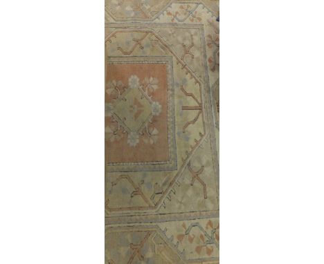 A Caucasian carpet, the central diamond and floral decorated medallions in cream, pale green, pale blue and salmon on a salmo