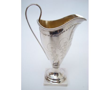 A late Victorian silver cream jug, Sheffield, 1892, makers mark WPD, of helmet form with beaded rim and loop handle, on squar