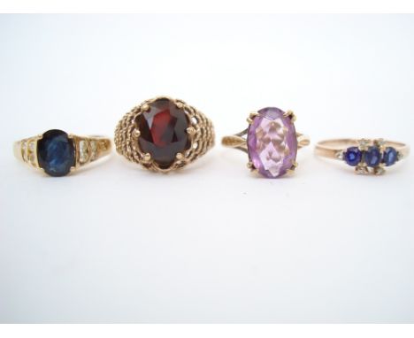 A Sapphire and eight stone diamond 14k ring, an amethyst 9ct ring, a garnet 9ct ring and three stone sapphire and diamond rin