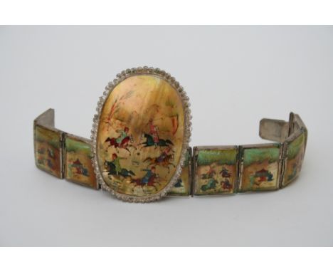 A Persian white metal hinged bracelet set with eight mother of pearl panels decorated with court and hunting scenes, together