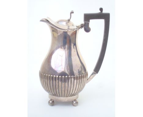 A George V silver hot water jug, Sheffield, 1913 by William Hutton & Sons Ltd, of baluster form, half fluted, with hinged cov