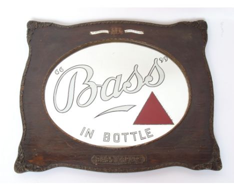 Breweriana / Advertising Interest.
An Edwardian 'Bass in a Bottle' oval advertising mirror in shaped oak and gesso frame, bea