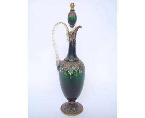 A late 19th Century Moser enamelled green glass claret jug and stopper, of amphora form, on domed circular foot with clear gl