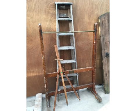 A VINTAGE WOODEN CLOTHES RAIL ON CASTORS, A WOODEN EASEL AND A SET OF SIX RUNG STEP LADDERS 