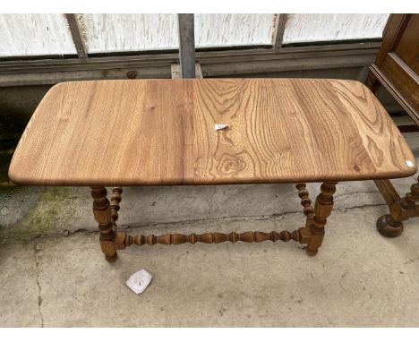 A VINTAGE ERCOL ELM COFFEE TABLE ON TURNED LEGS, 41x18" WIDE 