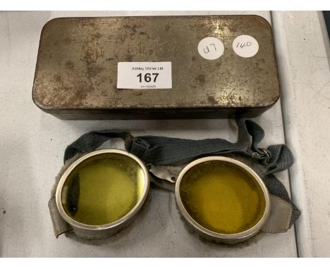 A TIN CONTAINING A PAIR OF VINTAGE FLYING GOGGLES 