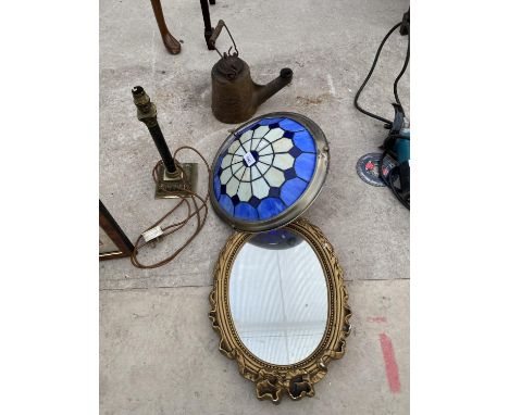 THREE ITEMS TO INCLUDE A GILT FRAMED OVAL MIRROR, AN ART DECO STYLE TABLE LAMP AND CAST IRON OIL BURNER 