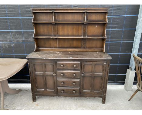 AN ERCOL ELM DRESSER WITH TWO DOORS, FOUR DRAWERS AND UPPER PLATE RACK 