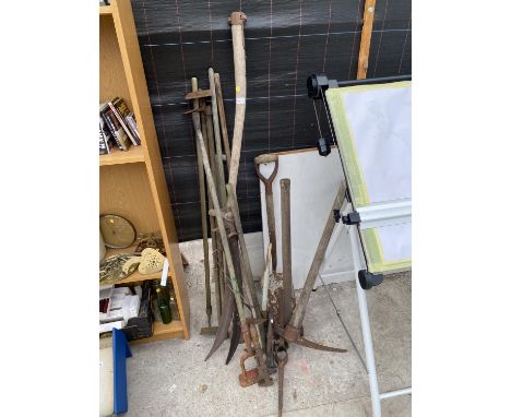 A COLLECTION OF VINTAGE GARDEN TOOLS TO INCLULDE PICK AXE, FORK, SPADE ETC. 