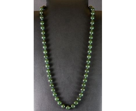 A single strand necklace of dark green jade beads.