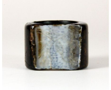 An unusual Chinese carved brown and white jade archers ring with a flattened and engraved white panel W.2.5cm