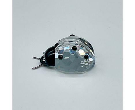 Clear body with black facets on back, black face with clear crystal eyes, metal antennae. Swarovski backstamp. This item has 