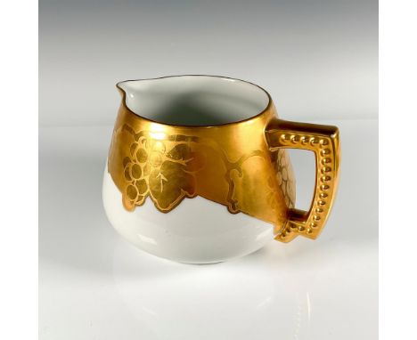 Ivory colored pitcher with thick gilded rim with grape motif and gilded handle with studs. Backstamped Vignaud Limoges in gre