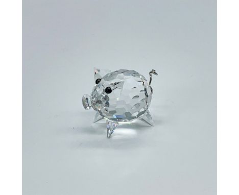 Clear, faceted body has wire corkscrew tail and black button eyes. Swarovski backstamp. This item has its original box which 