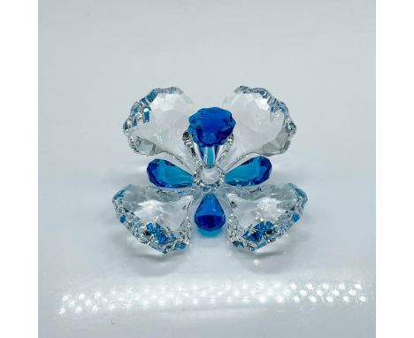 Clear faceted Swarovski Crystal Society figure of a flower with a bright blue pistil and accent petals. Swarovski mark. This 