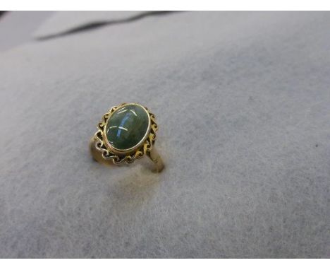 A 14k gold ring with jade set within a pierced mount, size N. 