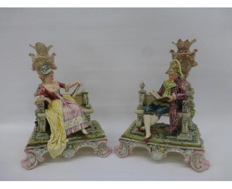 A pair of early Capodimonte ceramic classical seated figures with Rococo bases. 