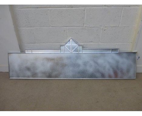An elongated wall mirror of architectural design.