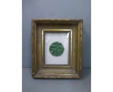 A carved jade cloud dragon mounted in a gilded 19th Century frame (under glass).