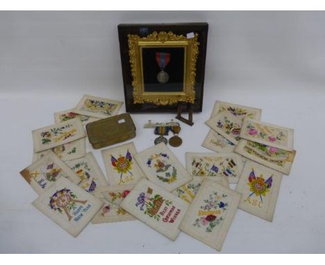 A WWI Christmas tin, various WWI embroidered postcards, two WWI medals awarded to Cpl. R Russell, North'd Fus. no. 3-8081 and