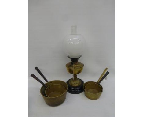 A set of three 19th Century brass and iron-handled saucepans and a Victorian brass oil lamp with funnel and shade.