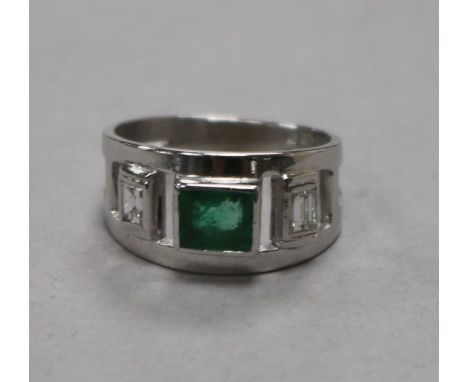 A modern 9ct white gold and emerald ring with diamond set shoulders, size K.