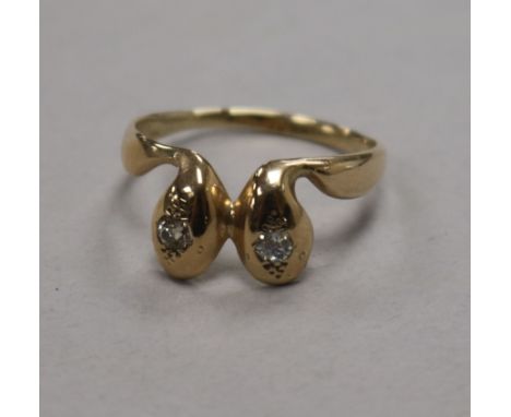 A yellow metal and diamond set twin serpent head ring, size S.