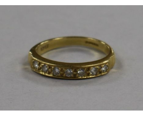 An 18ct gold and seven stone diamond half eternity ring, size R.