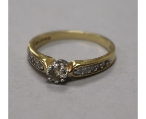 An 18ct gold and single stone diamond ring, with diamond set shoulders, size R.