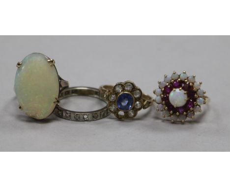 Three 9ct gold gem set rings including white opal, together with a diamond eternity ring (1 stone missing).