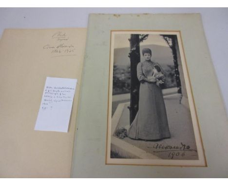 H.M. Queen Alexandra, full length portrait photograph of her holding a King Charles spaniel, signed Alexandra, 1906, 11.25ins